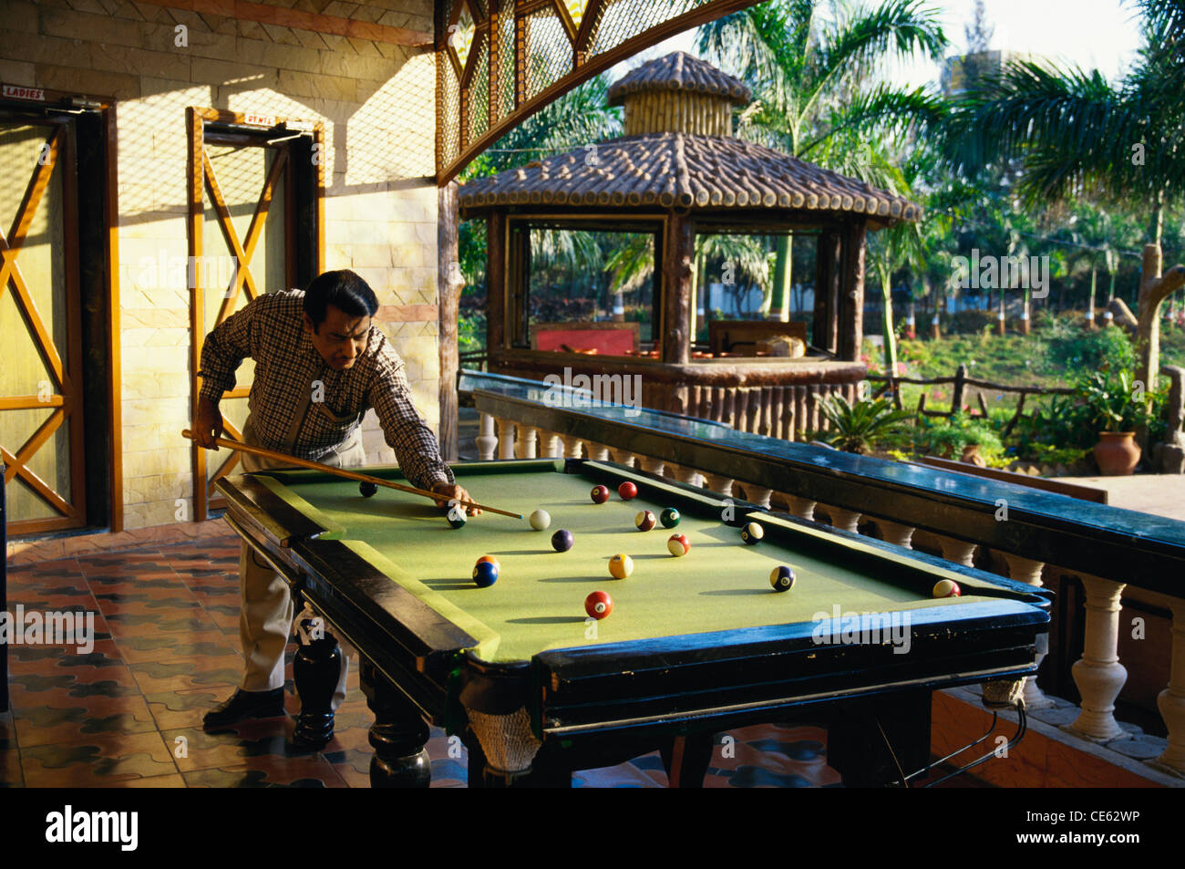 Homme indien jouant au billard frapper blanc de la boule de repère sur la table de billard ; Inde ; Asie ; modèle libéré Banque D'Images