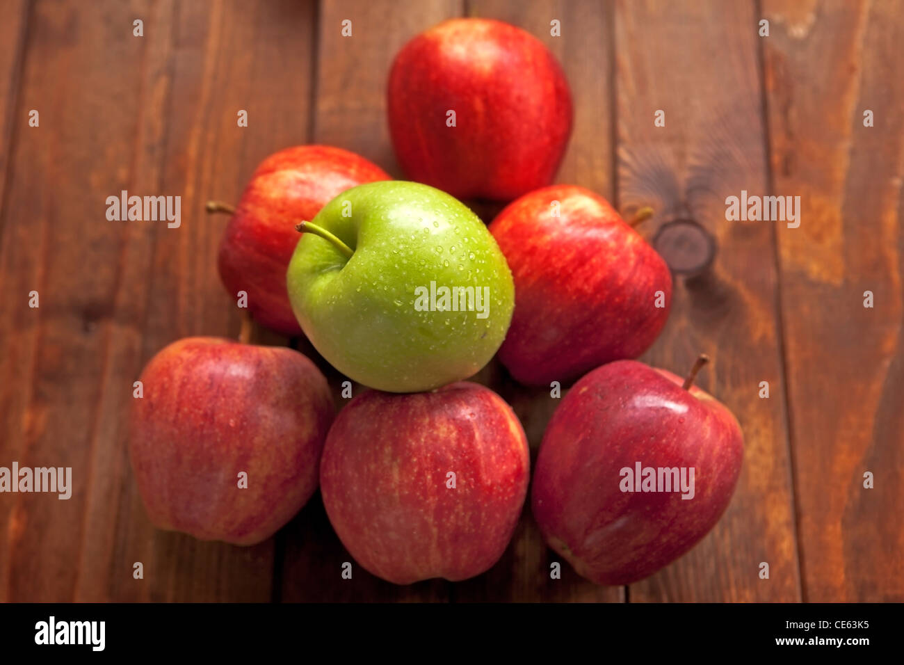 Pommes rouges avec une pomme verte Banque D'Images