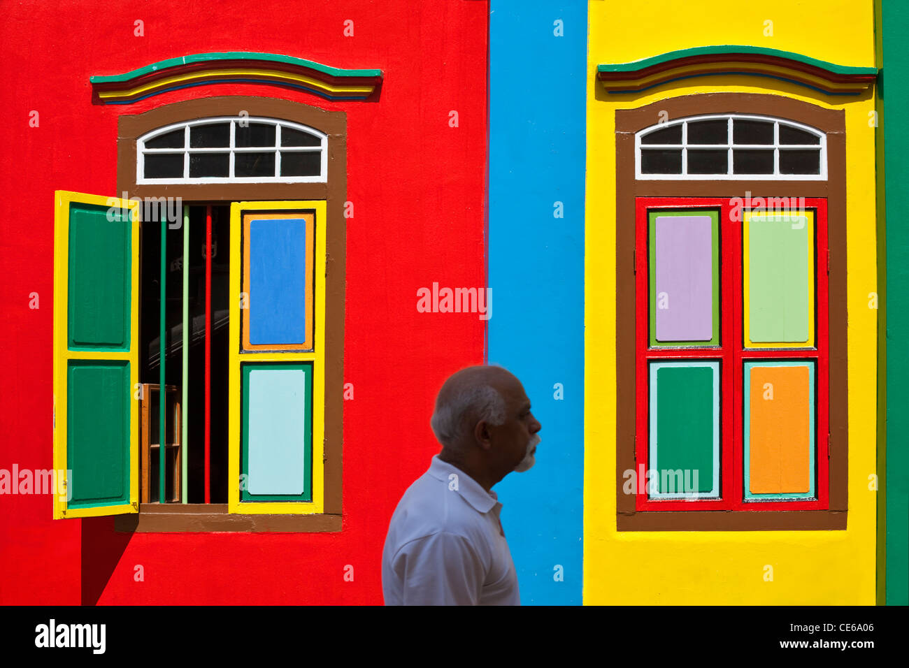 Homme marchant au-delà d'un colouful immeuble du patrimoine dans la région de Little India, à Singapour Banque D'Images