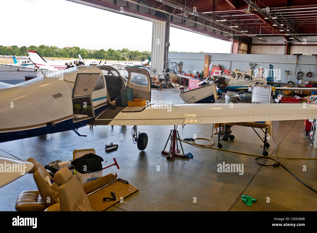 Un groupe de s'asseoir à l'intérieur de l'avion l'avion hanger ayant terminé les réparations du moteur d'avion d'être moteur d'avion mécanique. Banque D'Images