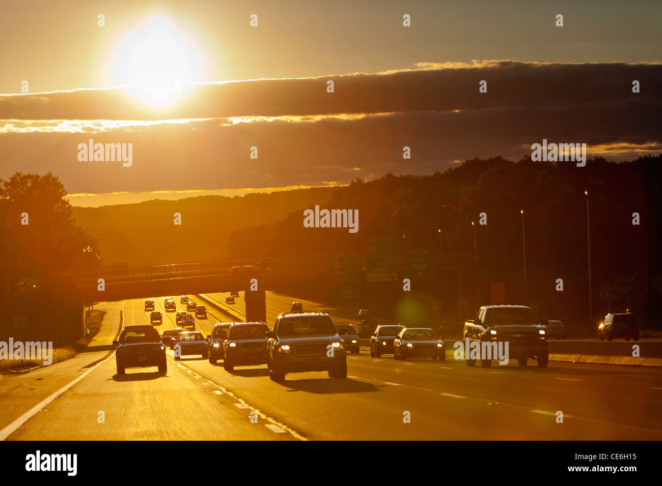 Coucher de soleil sur une grande autoroute avec des voitures et camions à leur voyage sur une route très fréquentée. Banque D'Images