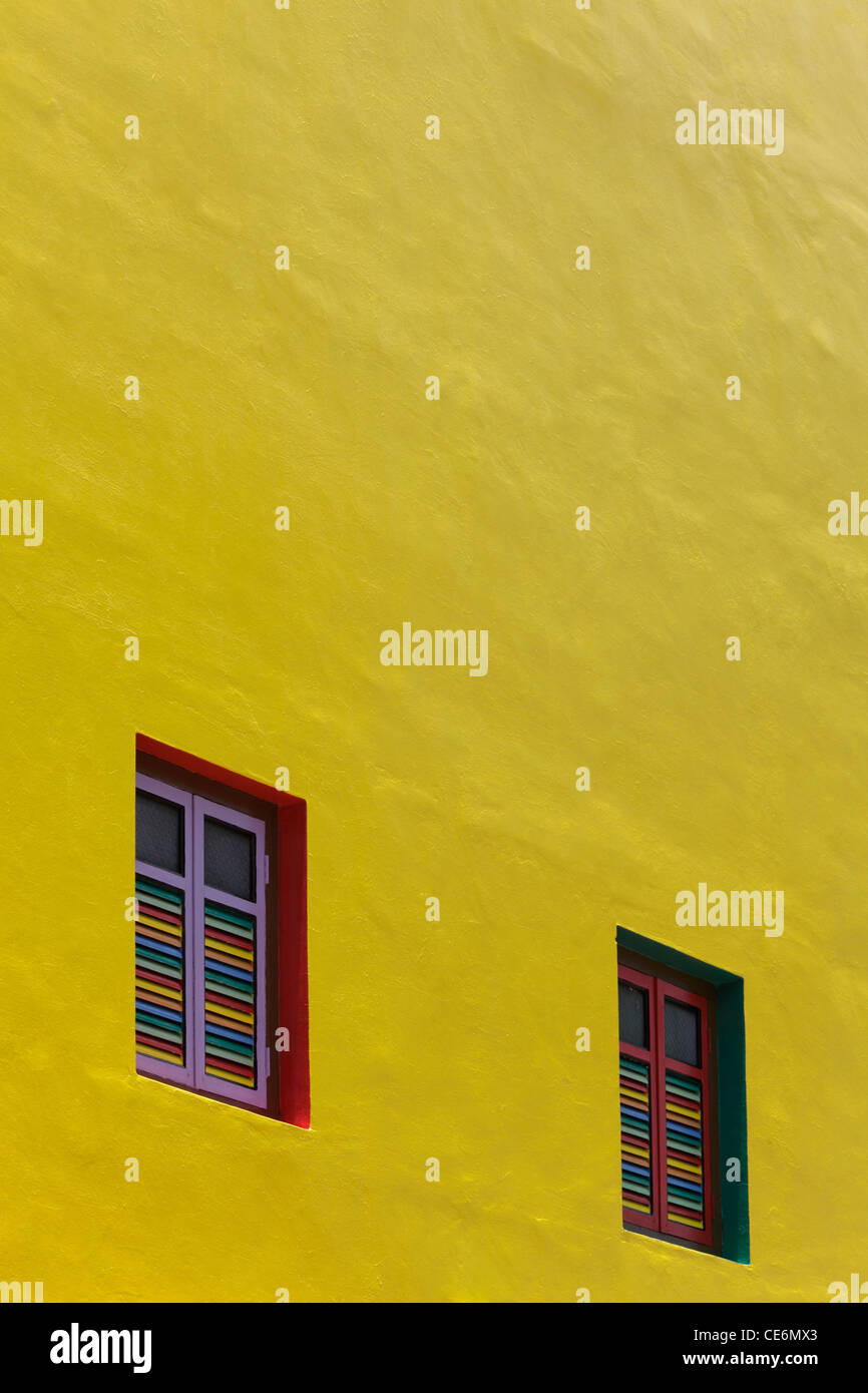 Mur peint en jaune avec des fenêtres de couleur Banque D'Images