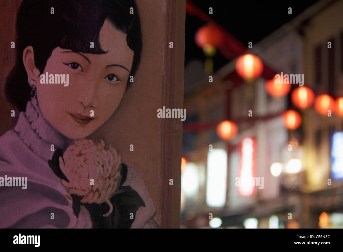 Affiche de Chinese woman's face au mur avec des lanternes en arrière-plan Banque D'Images