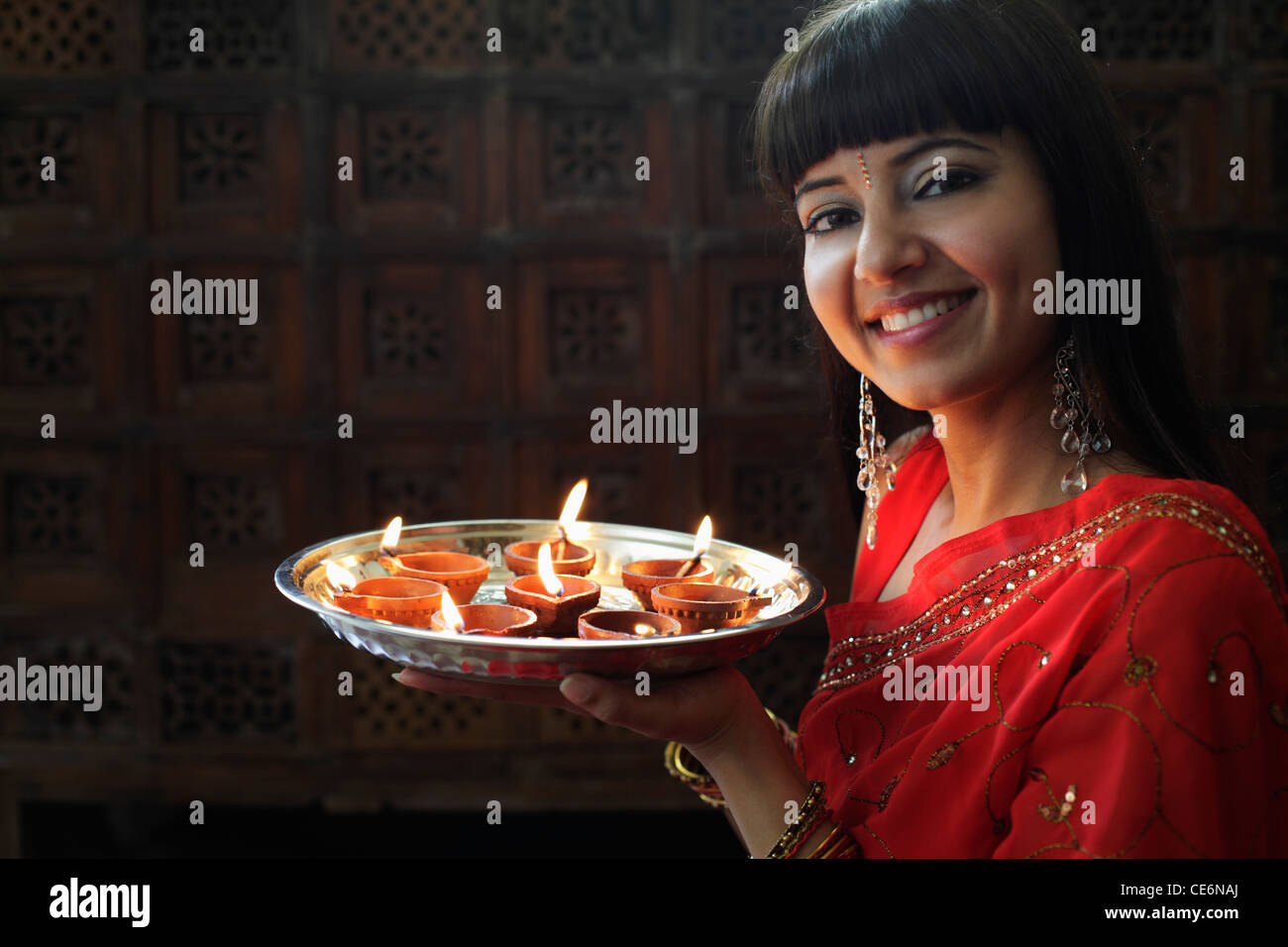 Indian woman holding tray of allumé des lampes à huile Banque D'Images