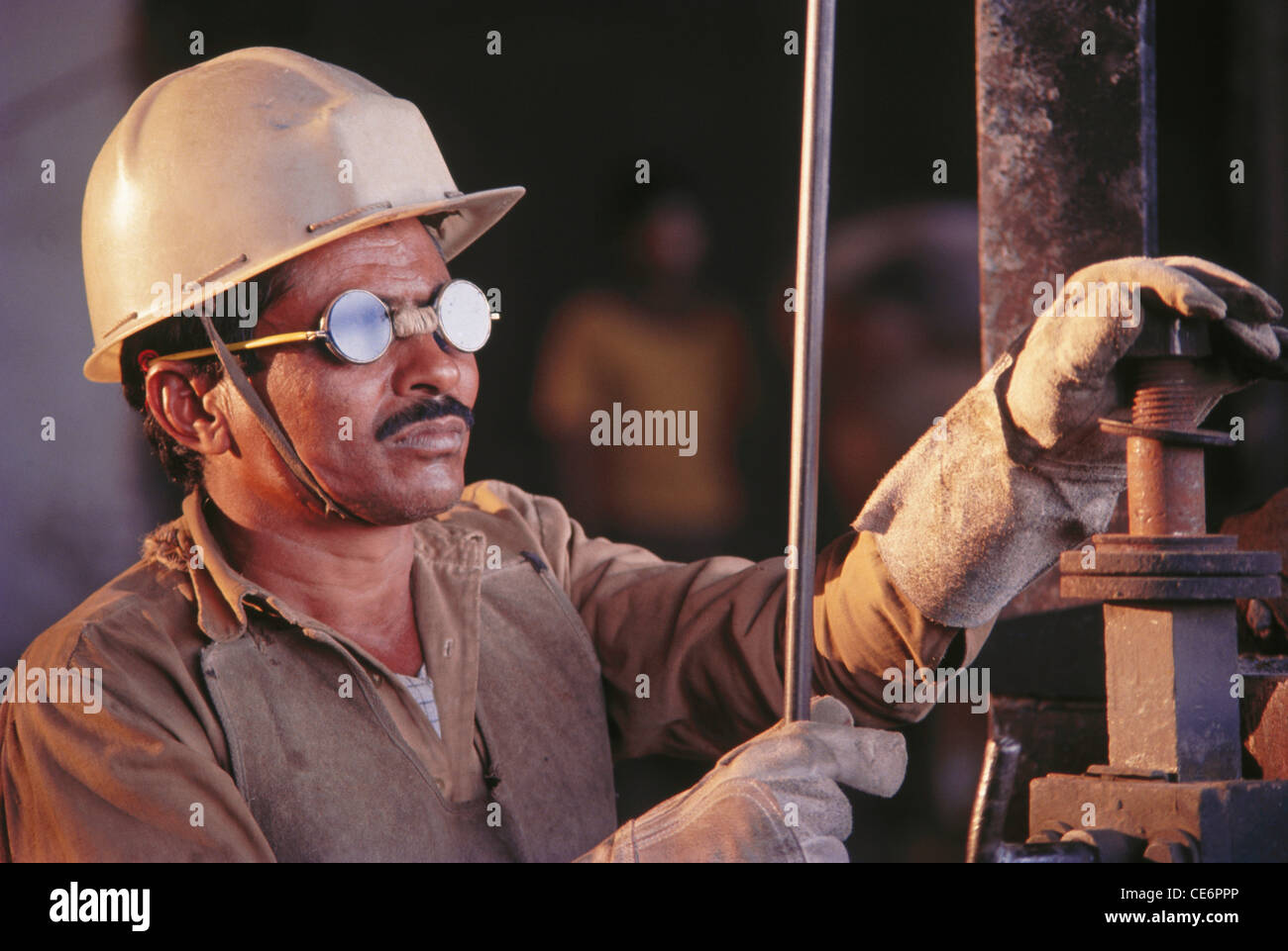 L'homme travaillant en usine portant des lunettes et casque de sécurité ; l'Inde Banque D'Images
