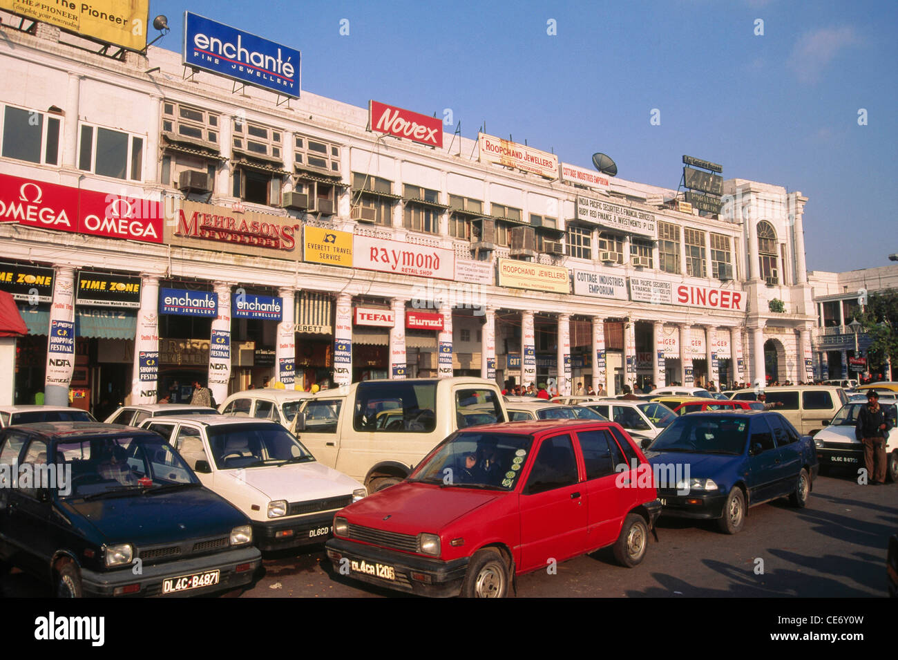 MMN 85523 : Connaught place boutiques enchante omega raymonds singer mehra fils maruti 800 parking rouge blanc bleu Delhi Inde Banque D'Images