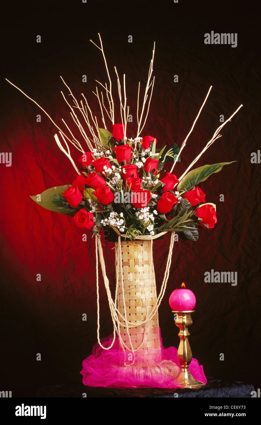 Arrangement artificiel de fleurs de roses rouges fleur avec bougie Banque D'Images