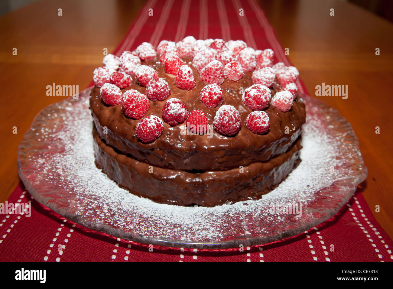 Ensemble de délicieux gâteau d'anniversaire avec ganache de chocolat et de framboises avec saupoudrage de sucre en poudre. Banque D'Images