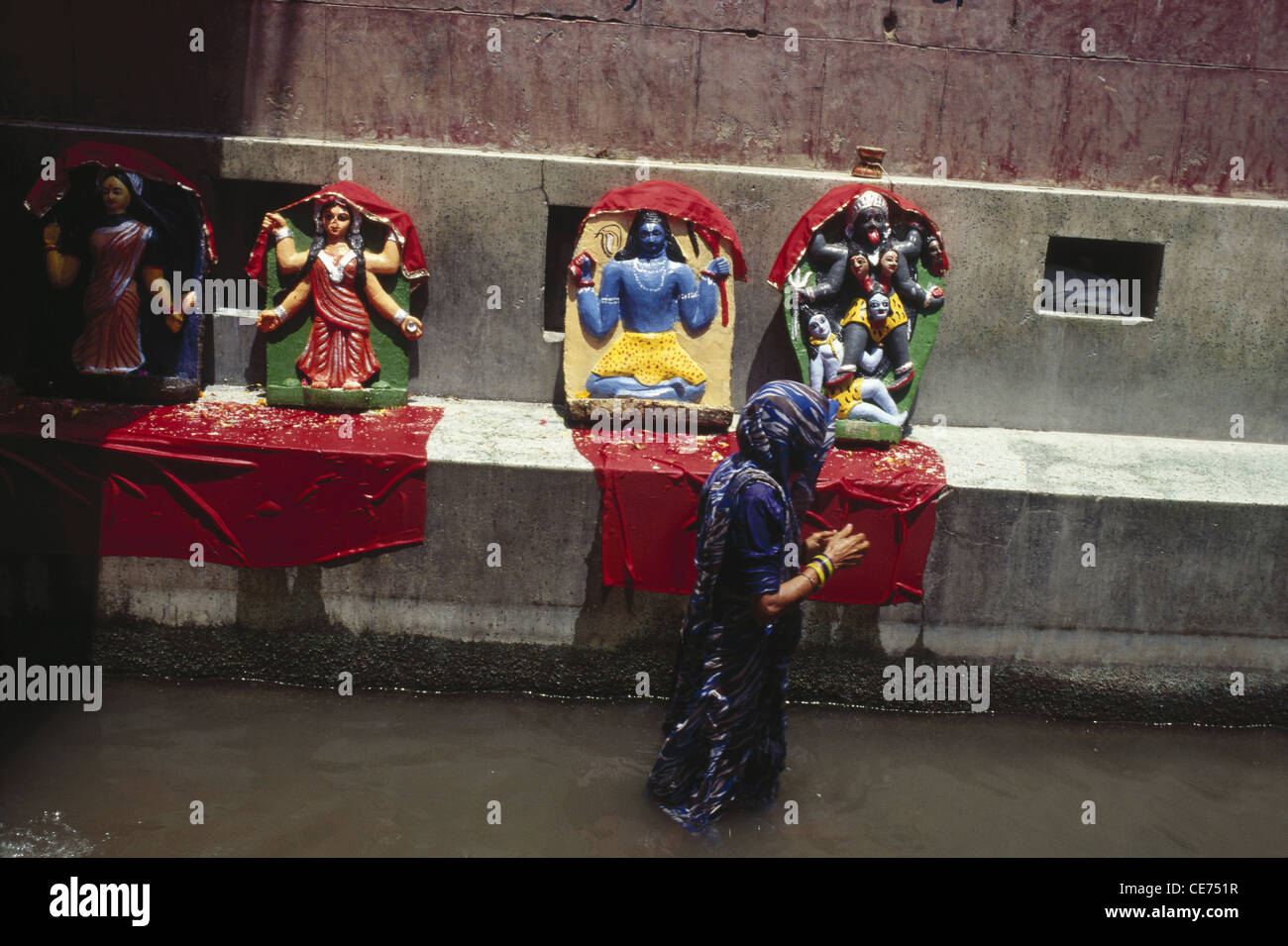 84555 SOA : femmes indiennes en priant dieux et déesse marcher dans l'eau chaude printemps rajgir Bihar en Inde Banque D'Images