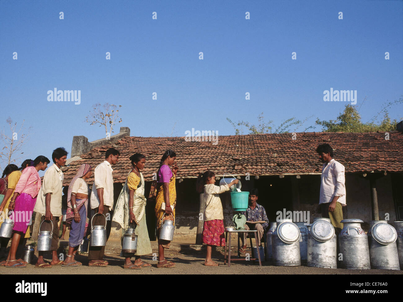 Faire la queue au centre de collecte de lait coopérative de lait dans le village du Gujarat Inde Asie Banque D'Images