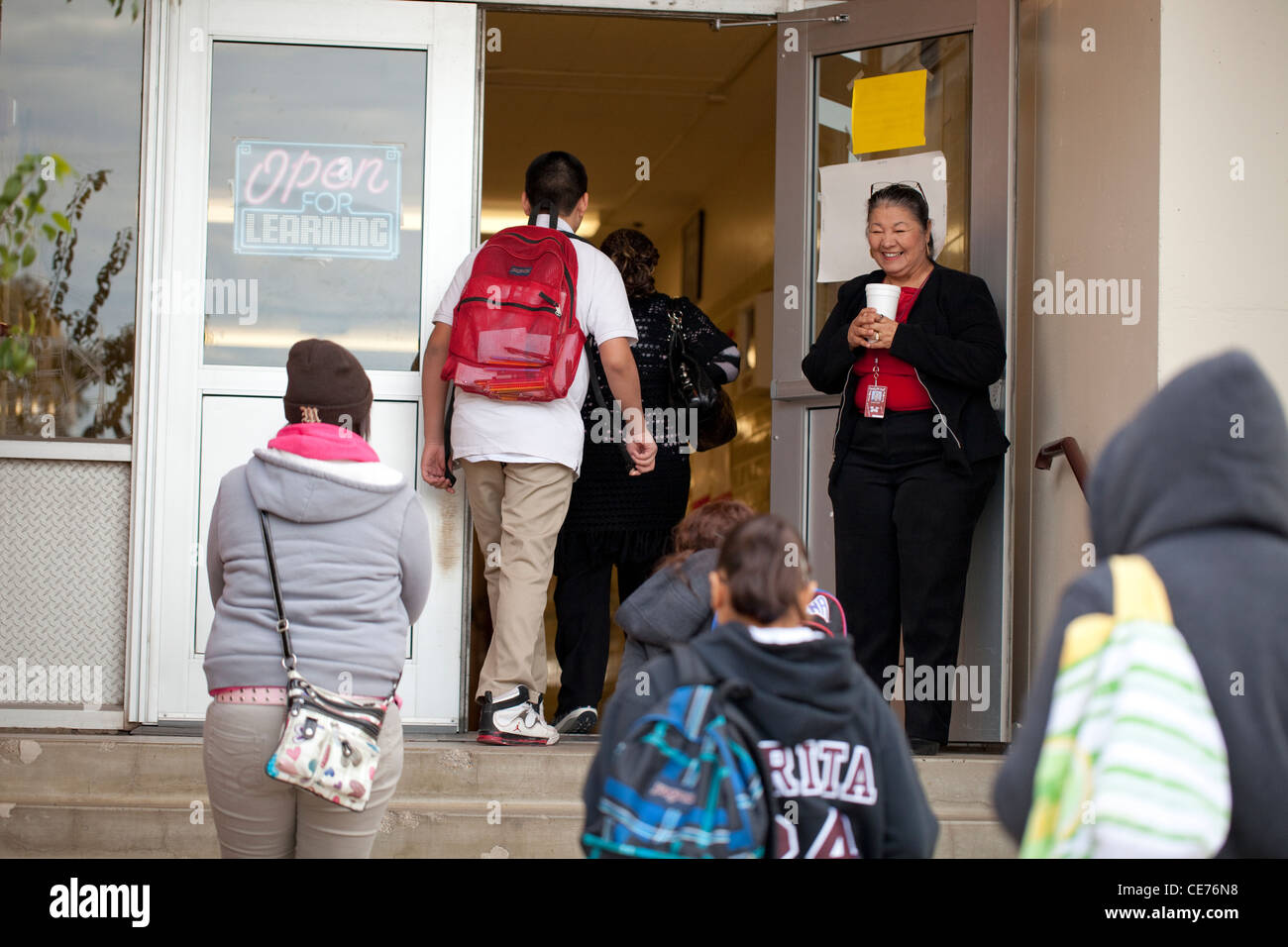 Young accueille les étudiants à l'école à la porte d'entrée de l'école secondaire Highland Banque D'Images