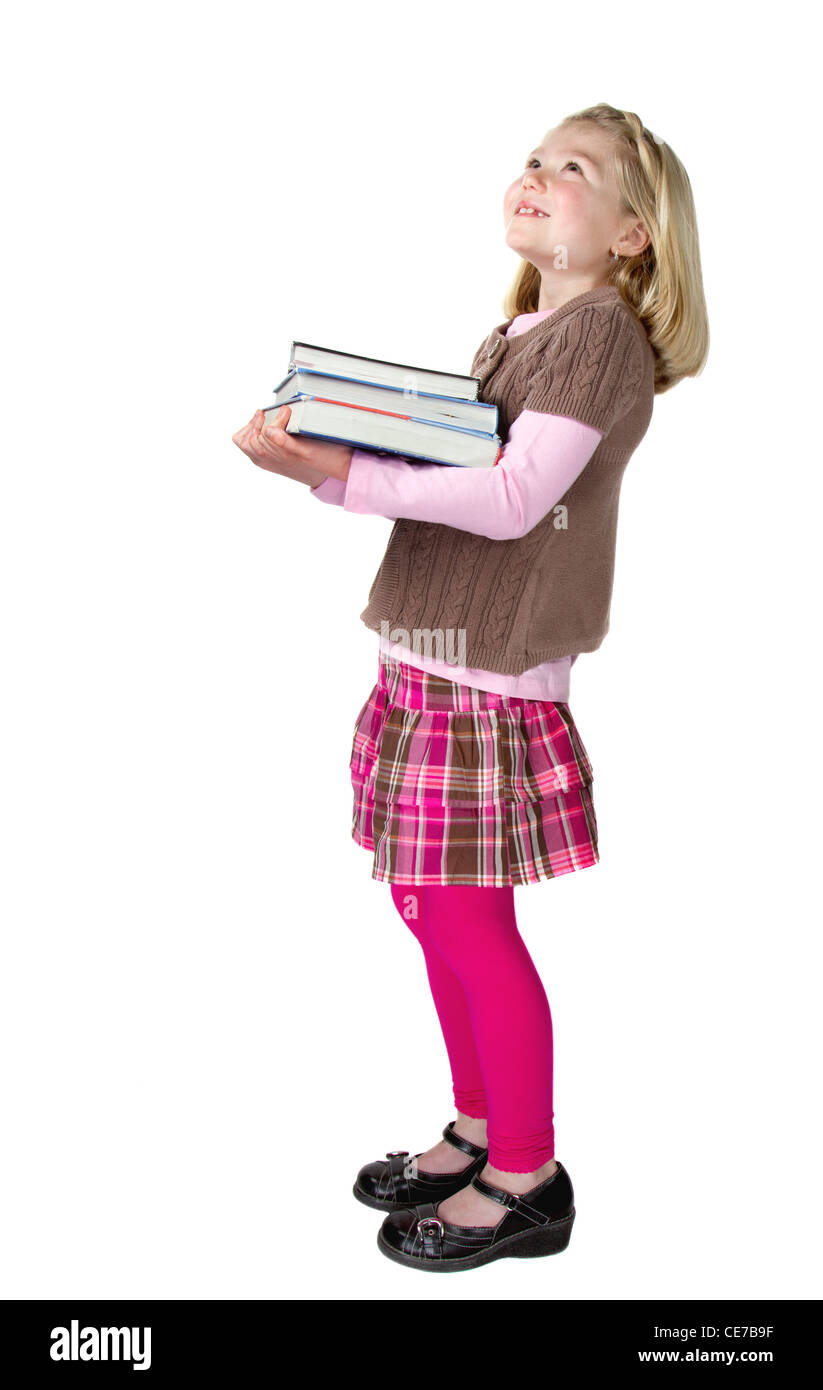 Un mignon school girl holding books et à la recherche jusqu'à quelque chose ou quelqu'un, isolé sur fond blanc Banque D'Images