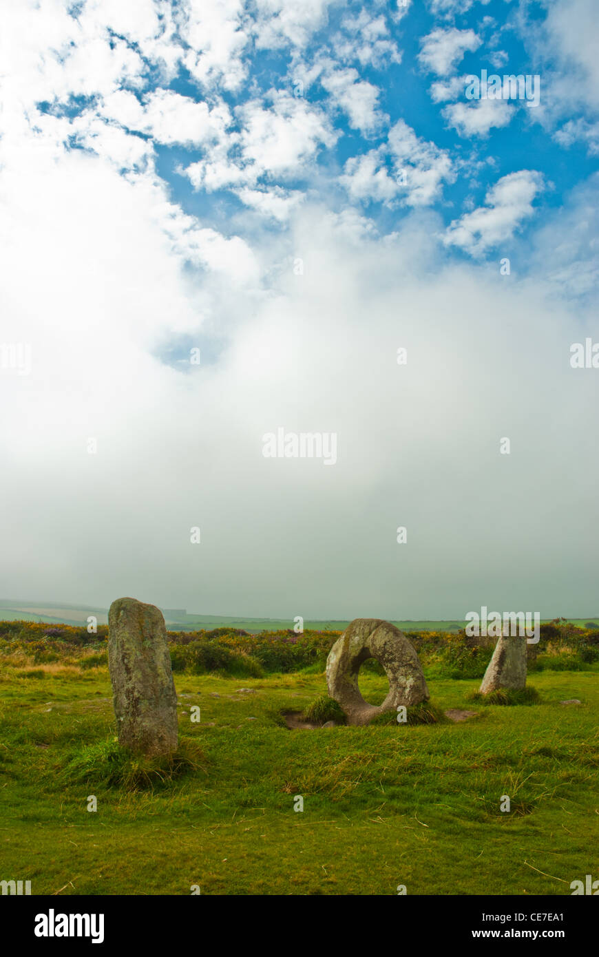 Men-an-tol, trois menhirs, l'un qui est 'trous', considérée comme un symbole de fécondité, Cornwall, UK. Site néolithique, éclairé par de soleil avec ciel dramatique Banque D'Images