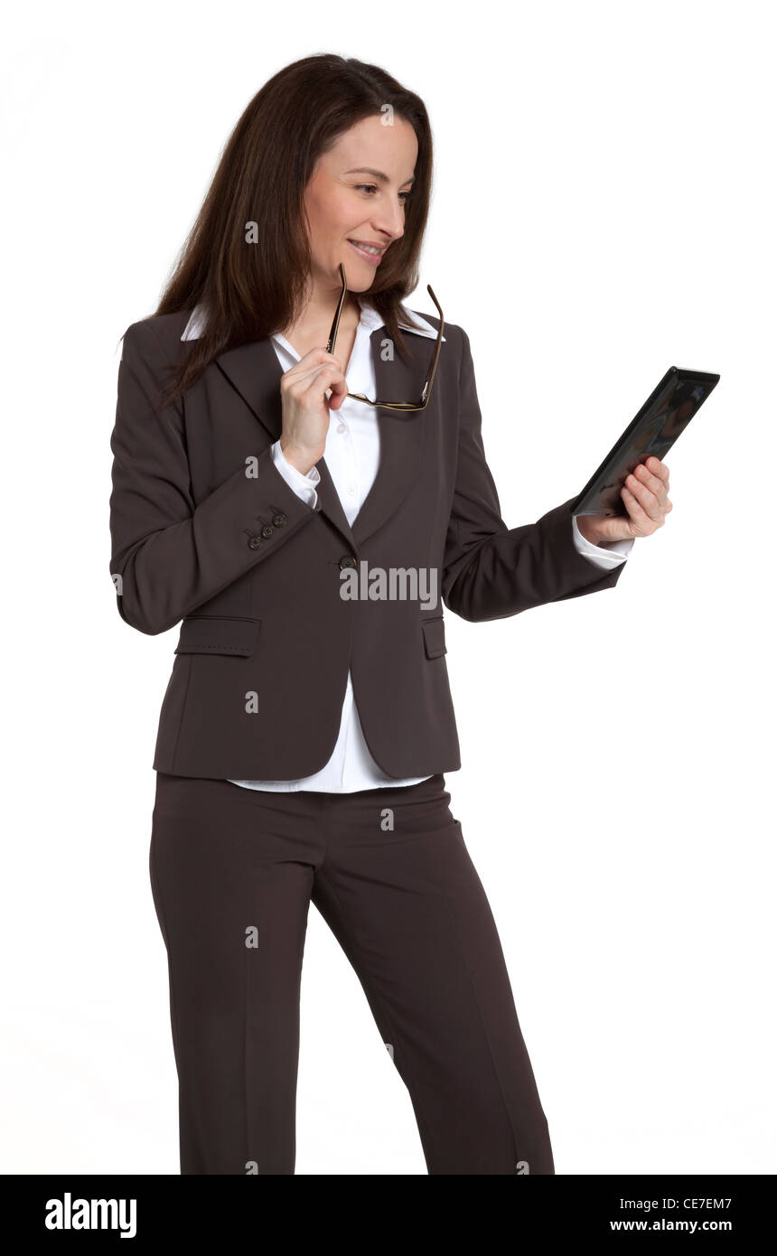 Attractive businesswoman holding et à la tablette à l'appareil contre un fond blanc. Banque D'Images