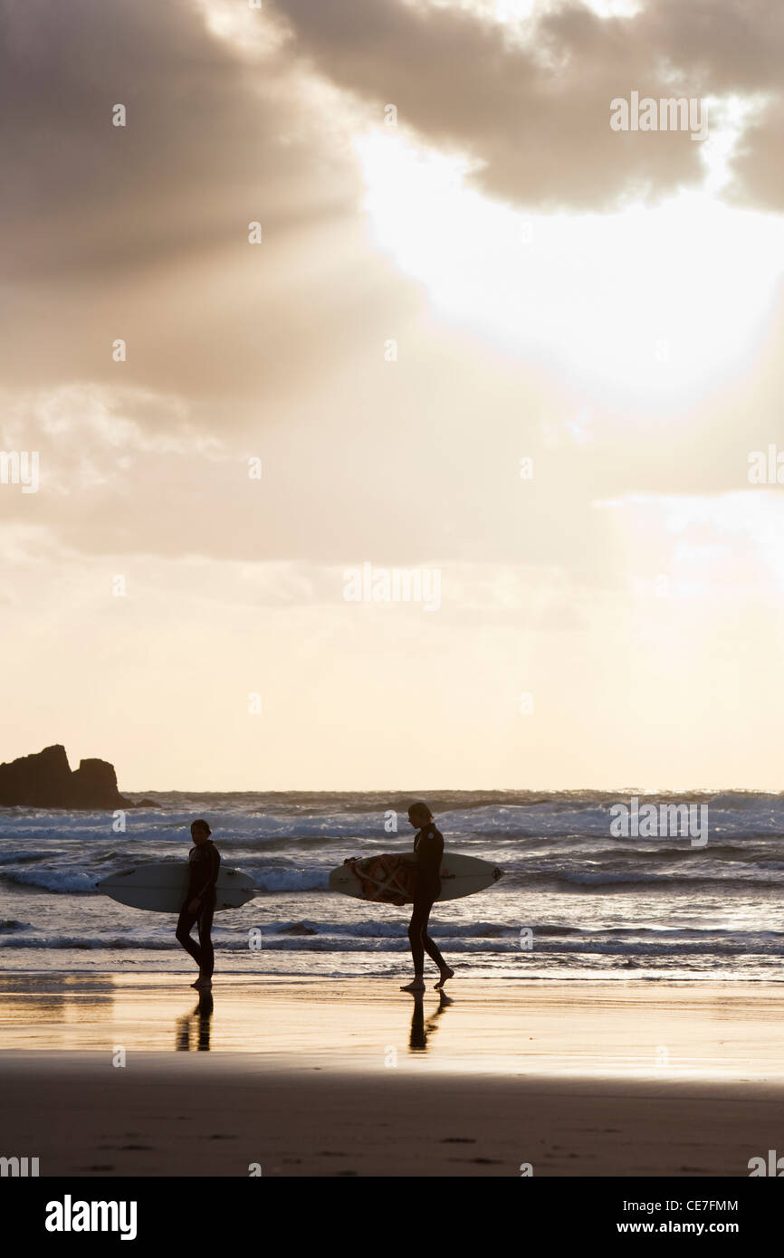 Surfeurs de Piha beach au coucher du soleil. Piha, Waitakere Ranges Regional Park, Auckland, île du Nord, Nouvelle-Zélande Banque D'Images