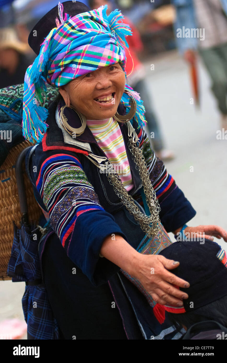 Une femme hilltribe vend un chapeau pour un client sur le marché de Sapa, Vietnam. Banque D'Images