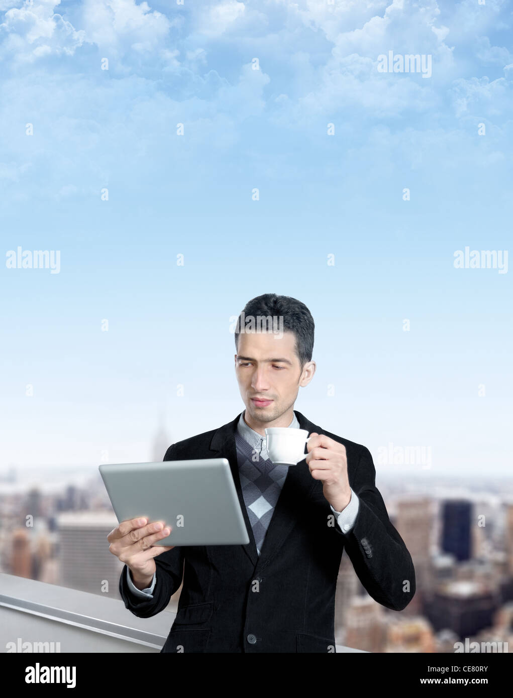 Jeune homme avec une tasse de café utilise une tablette numérique sur le toit d'un centre d'affaires. Cityscape floue avec des gratte-ciel Banque D'Images