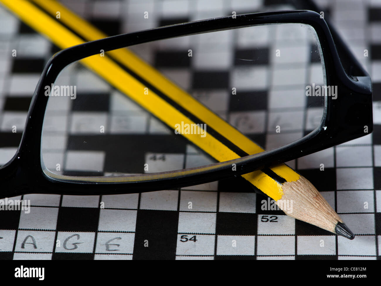 Une paire de lunettes de lecture située en haut d'une tournée vers le  crayon jaune et un grand mots croisés incomplète Photo Stock - Alamy