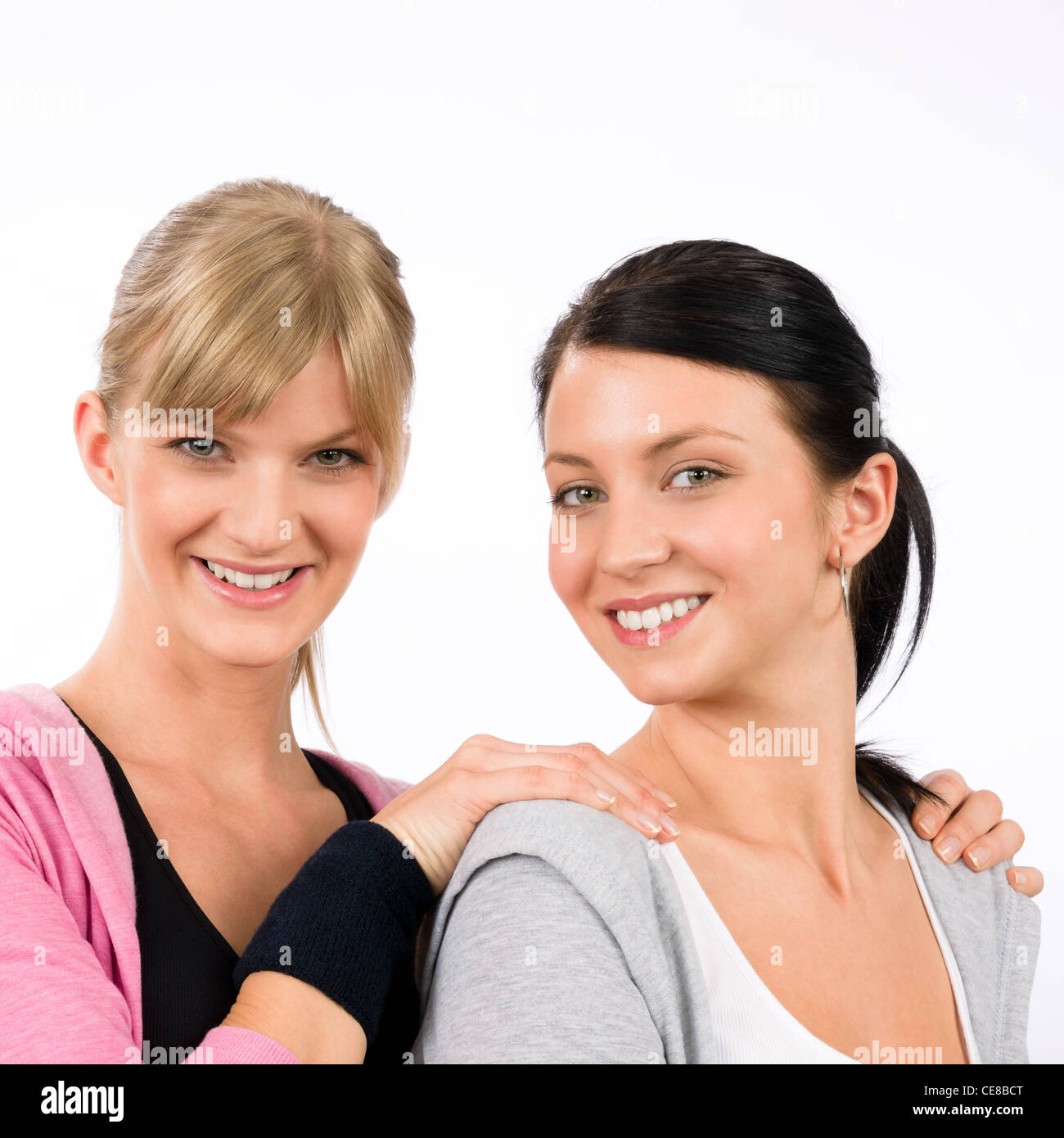 Deux femmes tenue sport amis hugging smiling portrait isolé Banque D'Images