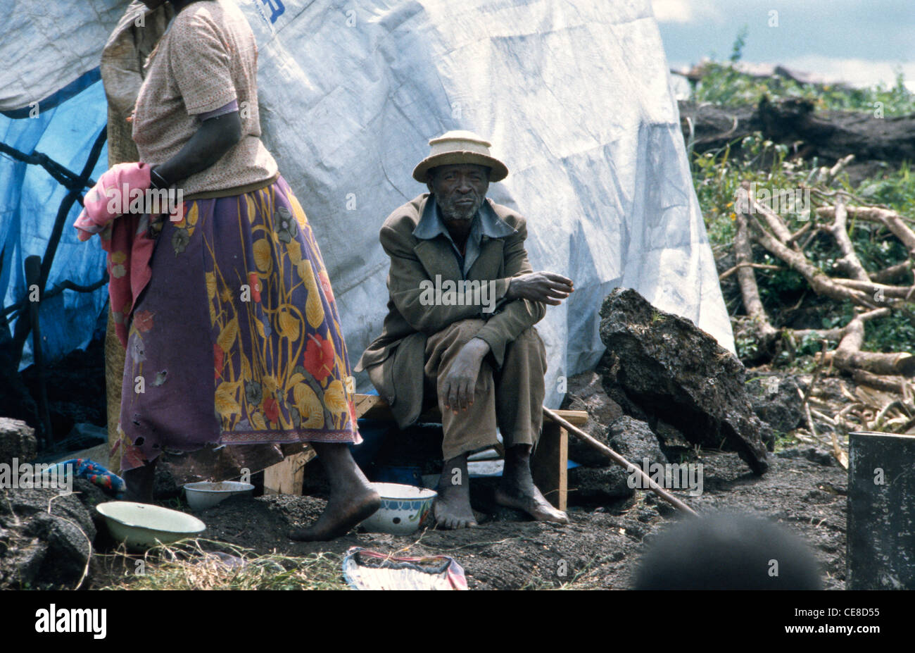 Homme assis par un logement temporaire dans le camp de réfugiés des Nations Unies pour les Hutus rwandais à Goma, République démocratique du Congo, l'Afrique Banque D'Images