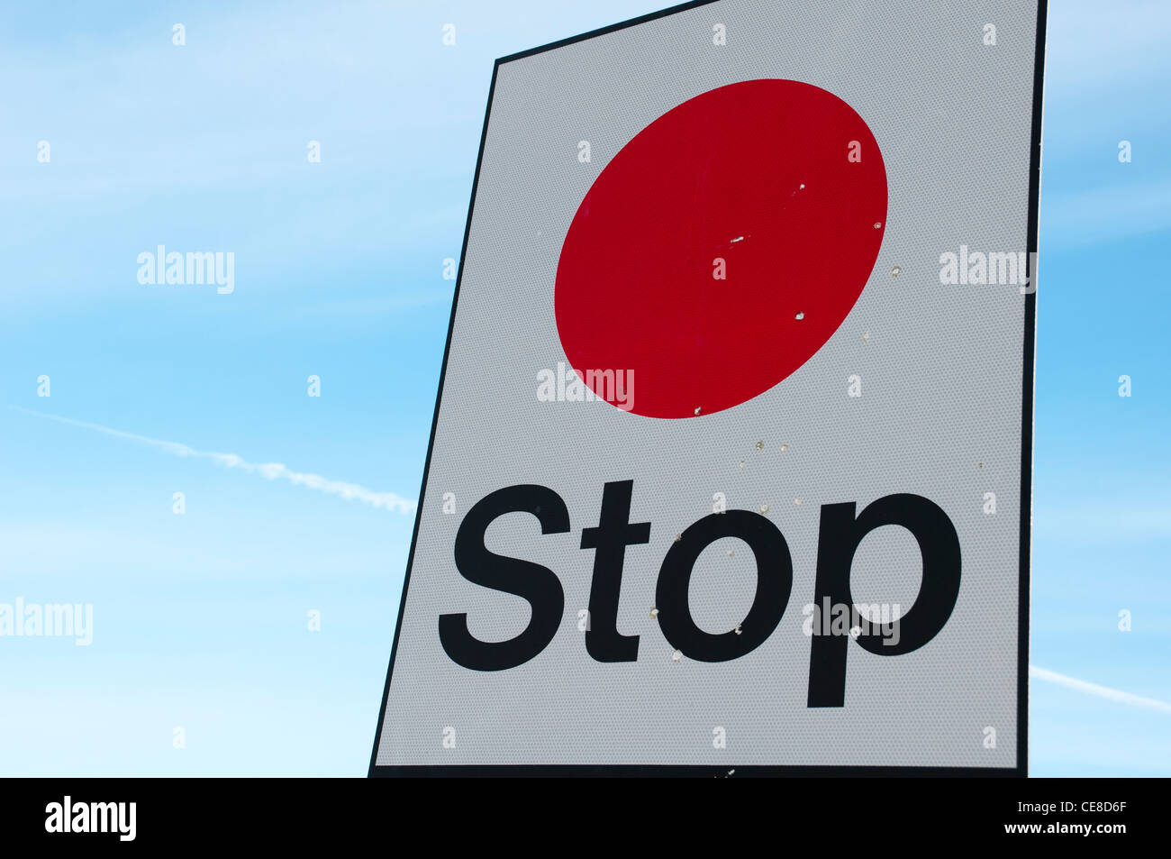 Un panneau d'arrêt rouge contre un ciel bleu. Banque D'Images