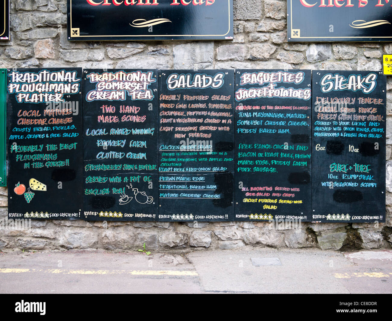 Une enseigne de pub britannique énumérant les denrées alimentaires d'être servi au sein de l'attraction touristique de Cheddar Gorge, Somerset, Angleterre. Banque D'Images