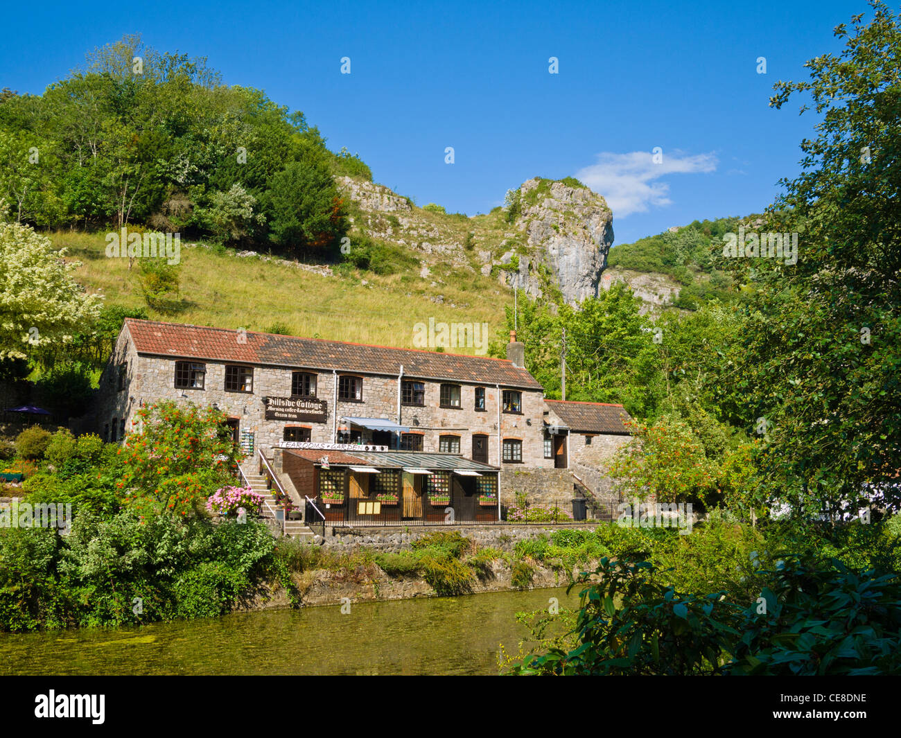 Un cottage et un salon de thé surplombant l'étang du moulin à Cheddar gorge, Somerset, Angleterre. Banque D'Images