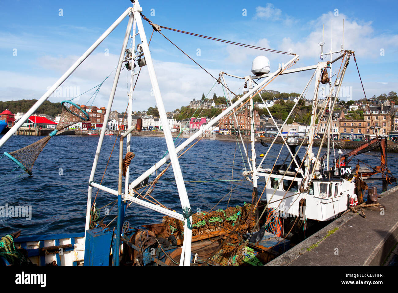 Oban, côte ouest, Ecosse, Royaume-Uni mer mur du port et des magasins de la ville et bateau de pêche Banque D'Images