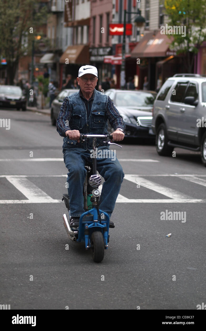 Man riding scooter sur Bedford Avenue, Brooklyn, New York Banque D'Images