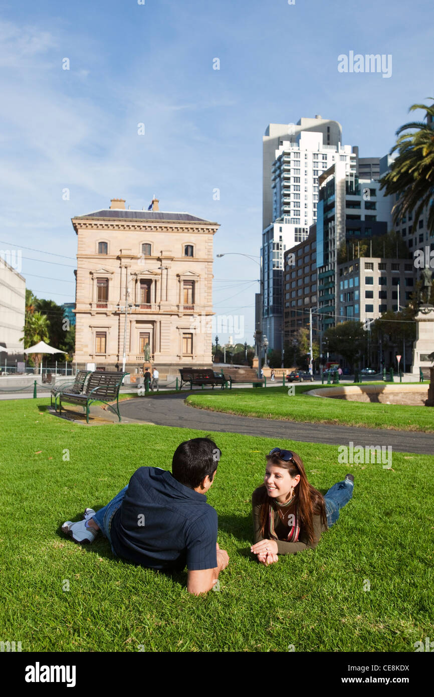 Young couple relaxing in park with city skyline en arrière-plan. Gordon, Melbourne, Victoria, Australie Banque D'Images