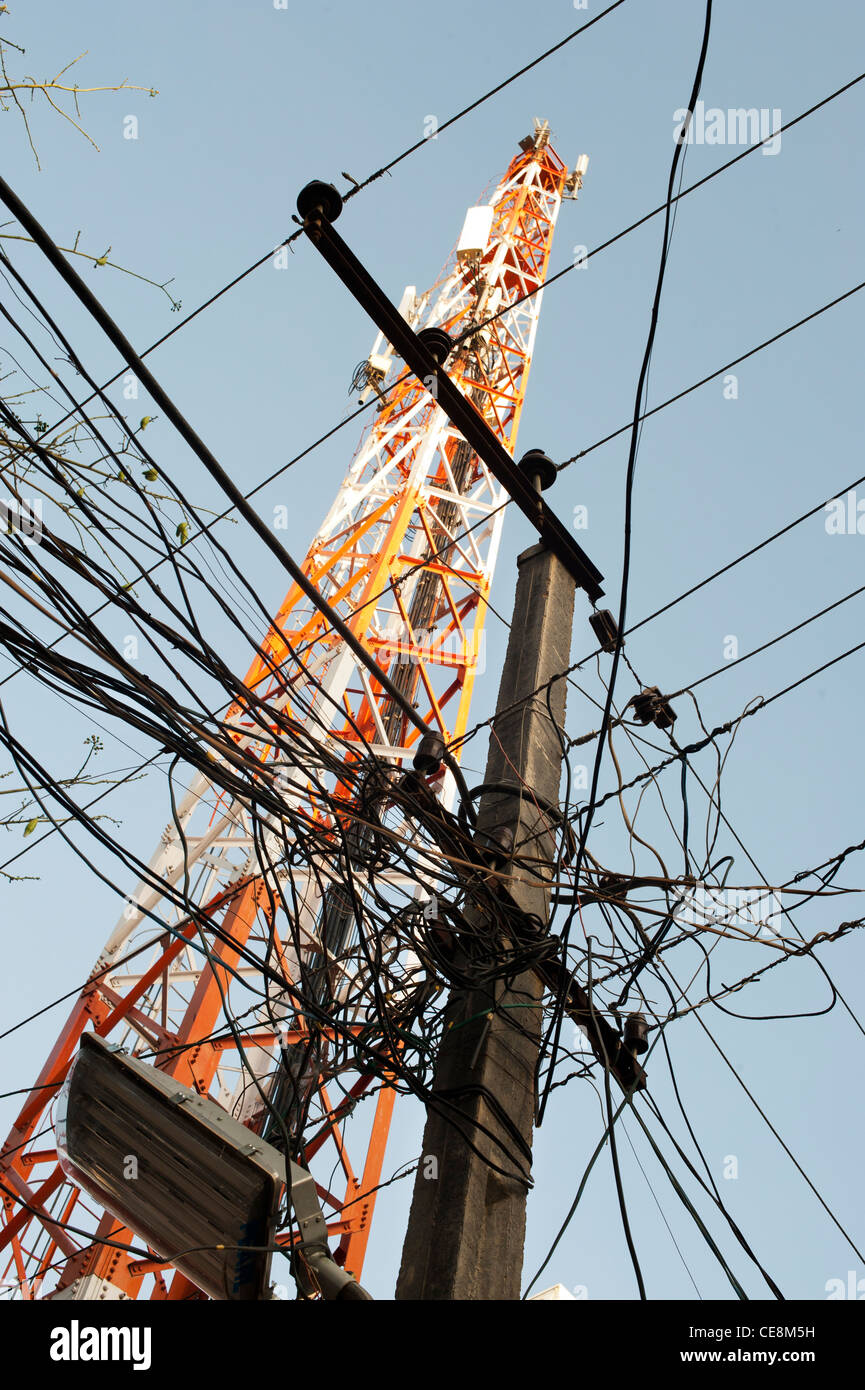 Pylône de l'électricité et les câbles à l'avant d'une tour de télécommunication dans une rue indienne. L'Andhra Pradesh, Inde Banque D'Images