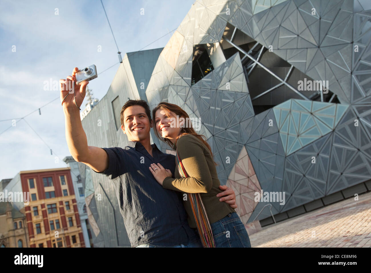Couple de visites dans la ville, de prendre une photo. Federation Square, Melbourne, Victoria, Australie Banque D'Images