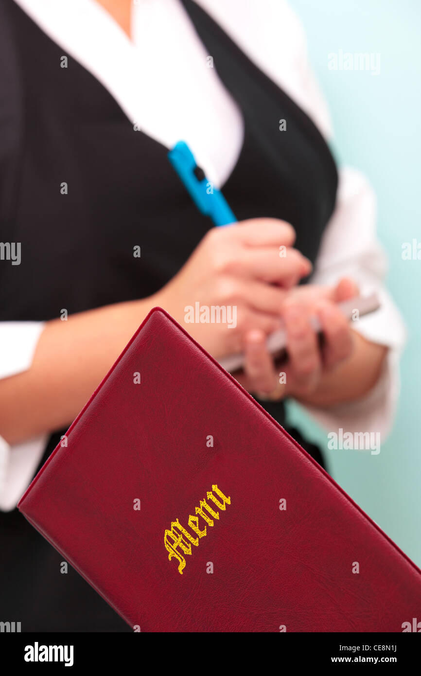 Photo d'un menu de restaurant avec une serveuse méconnaissables dans l'arrière-plan prendre une commande Banque D'Images