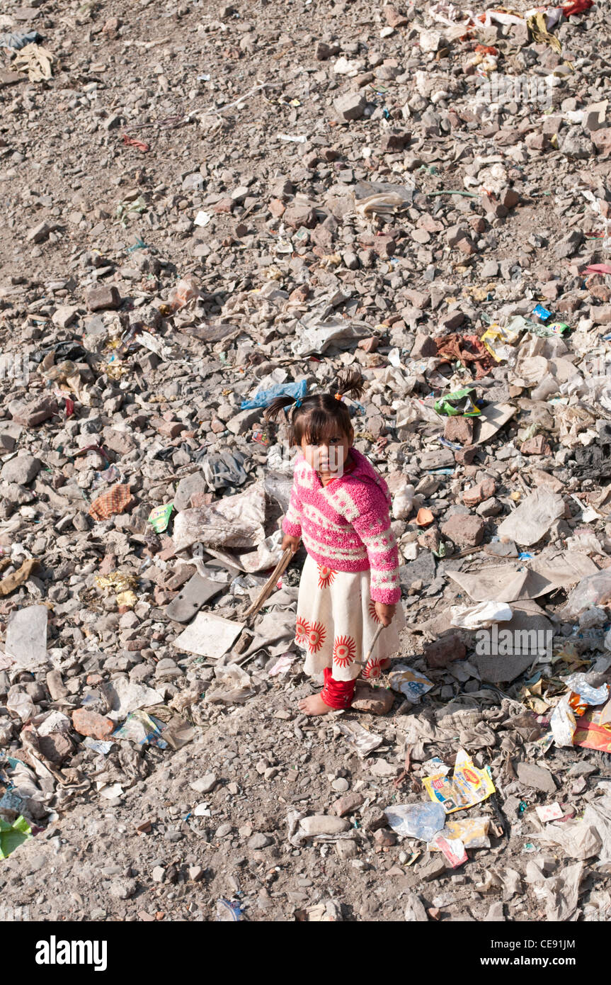 Petite fille jouant dans la rivière à sec qui est plein d'ordures, Rishikesh, Inde, Uttarakhand Banque D'Images