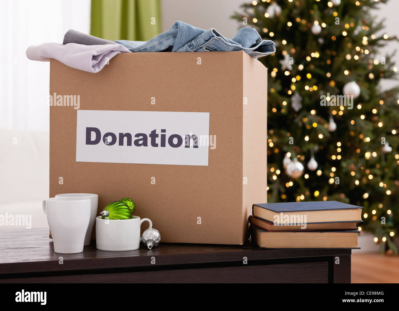 États-unis, Illinois, Metamora, boîte en carton avec des vêtements dans la salle de séjour, arbre de Noël en arrière-plan Banque D'Images