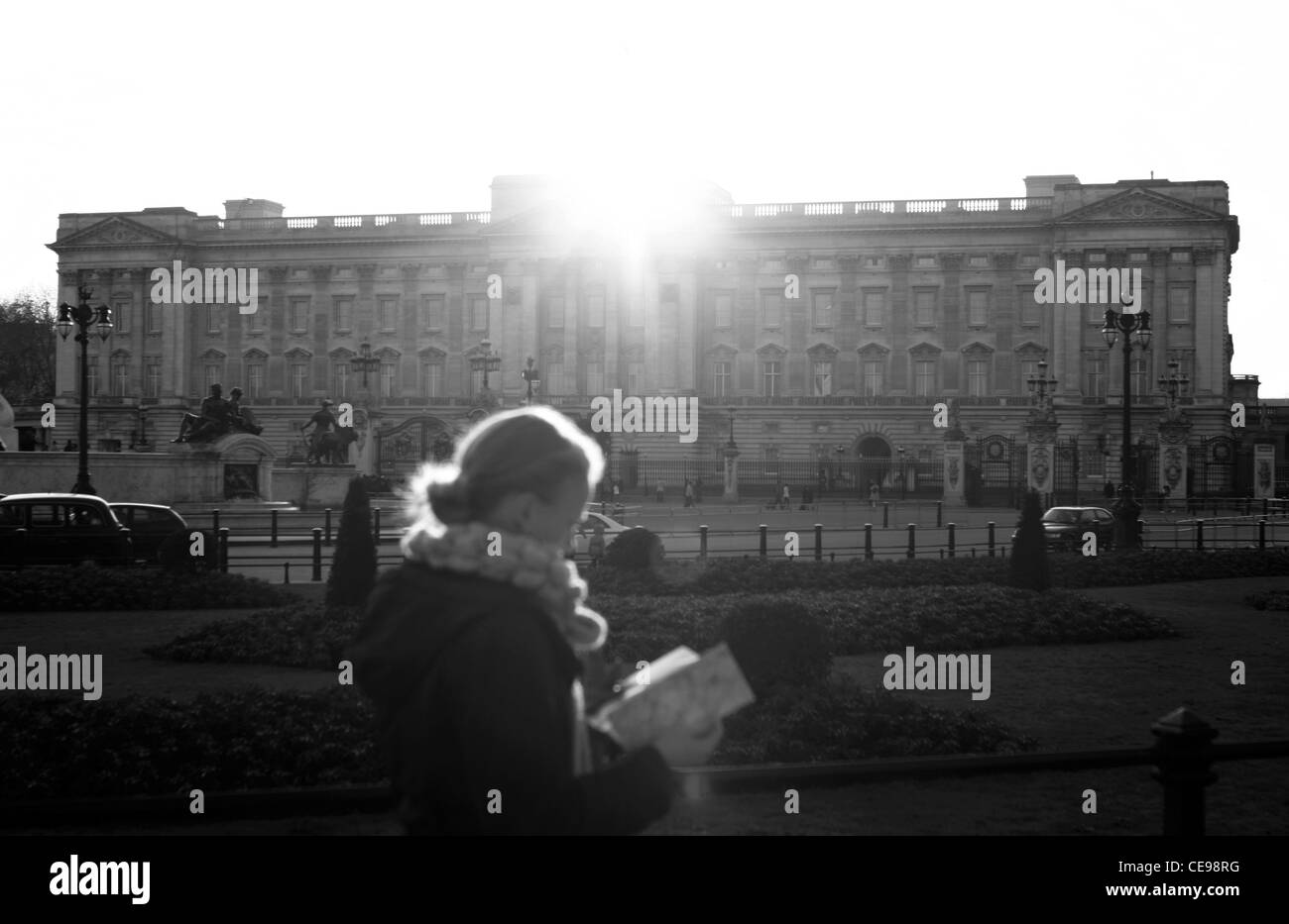 Buckingham Palace avec une dame lecture informations touristiques au premier plan comme elle marche adoptée Banque D'Images