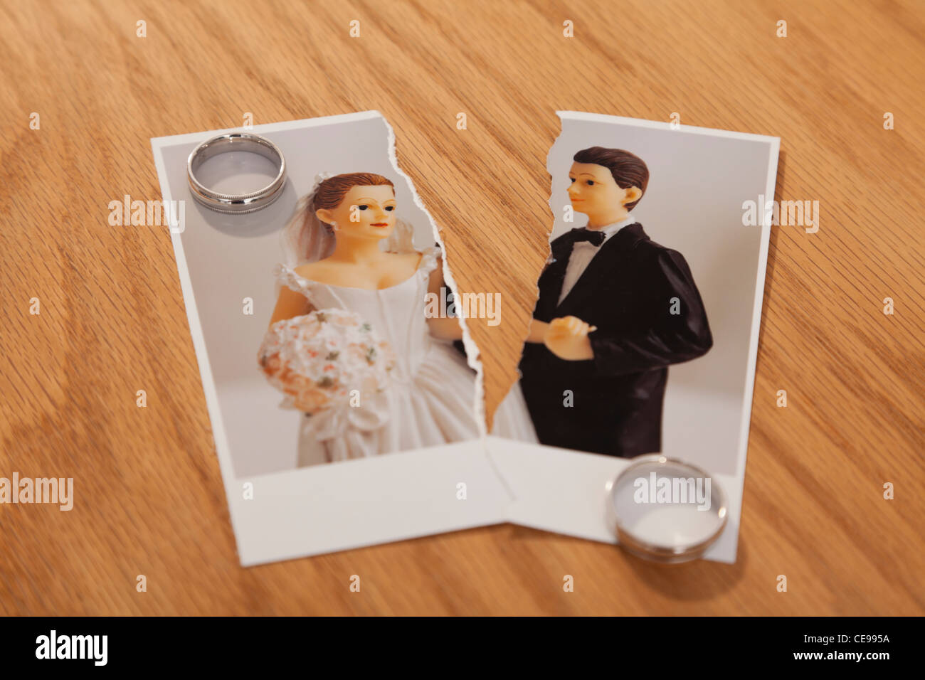 Studio shot of photo de jeunes mariés figurines coupé en deux et les anneaux de mariage Banque D'Images