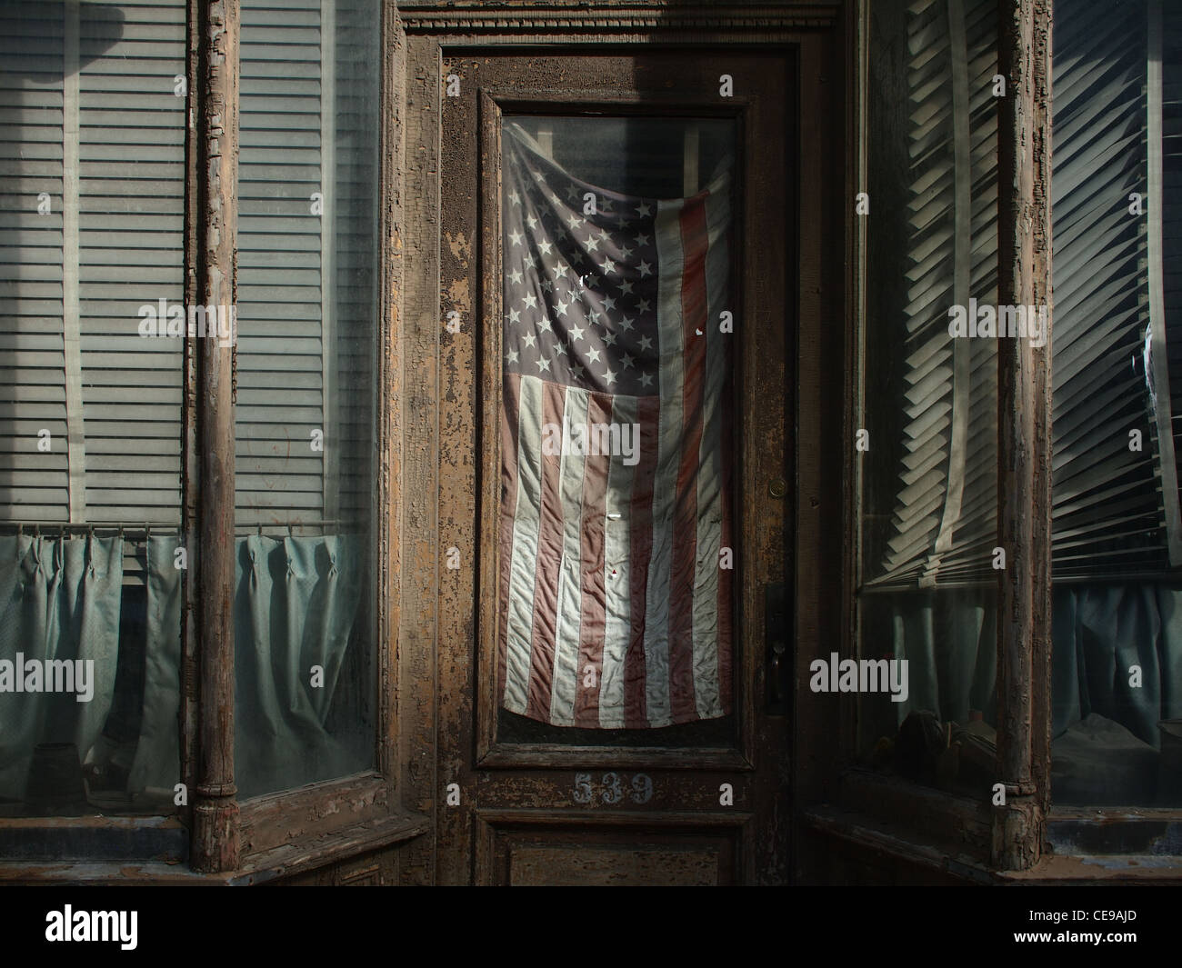 Ancien drapeau américain dans la porte de la boutique vide, Brooklyn, New York Banque D'Images