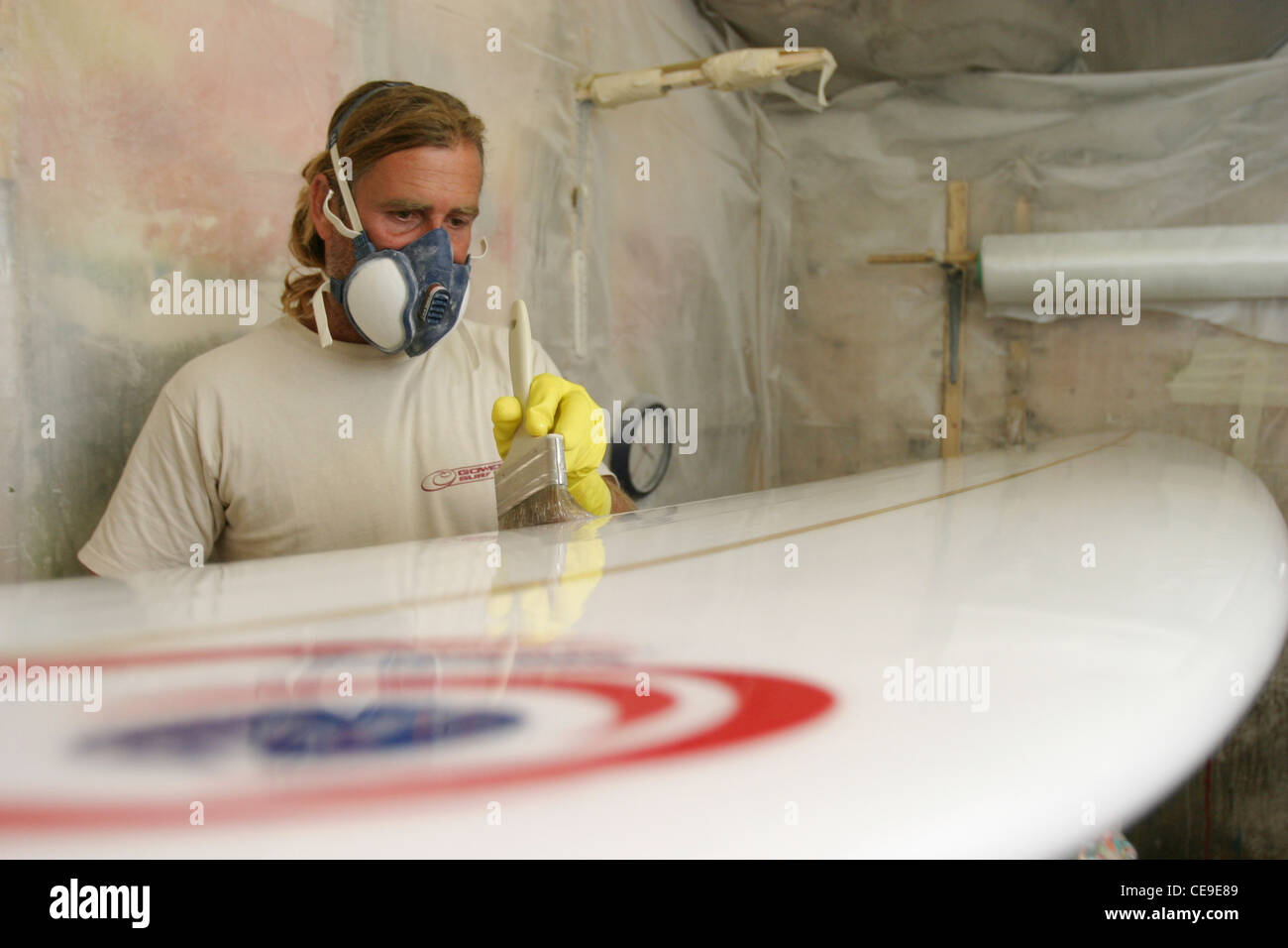 Shaper Surfboard Courage Chris Griffiths verres un surf dans son usine, Gower, Nouvelle-Galles du Sud Banque D'Images