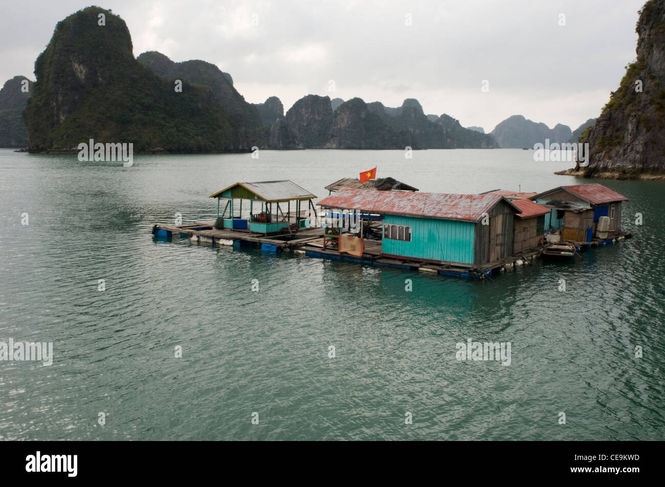 Beaucoup de gens vivent dans de petites communautés de maisons flottantes parmi les spectaculaires falaises de calcaire de la Baie d'Halong au Vietnam du Nord. Banque D'Images