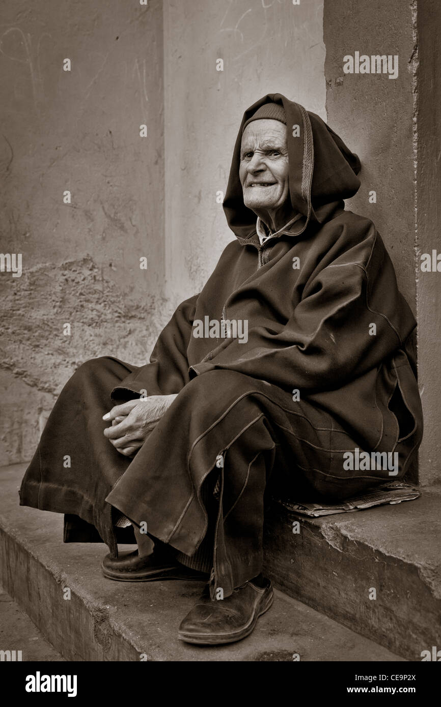 Un homme âgé assis sur les marches, Marrakech, Maroc Banque D'Images