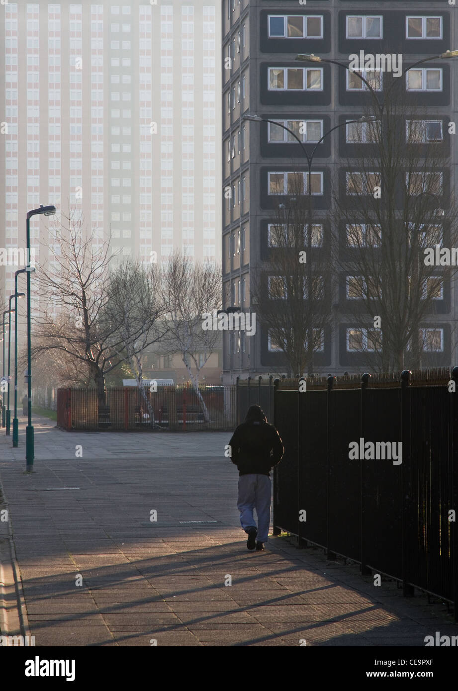Jeune homme marchant à travers Pendleton Housing Estate, centrale Salford, Greater Manchester, Angleterre, RU Banque D'Images