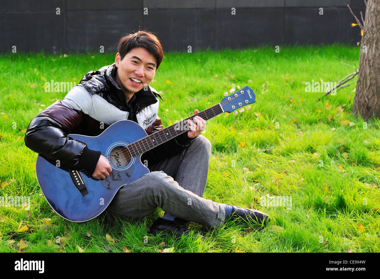 L'homme asiatique qui joue de la guitare dans un jardin Photo Stock - Alamy