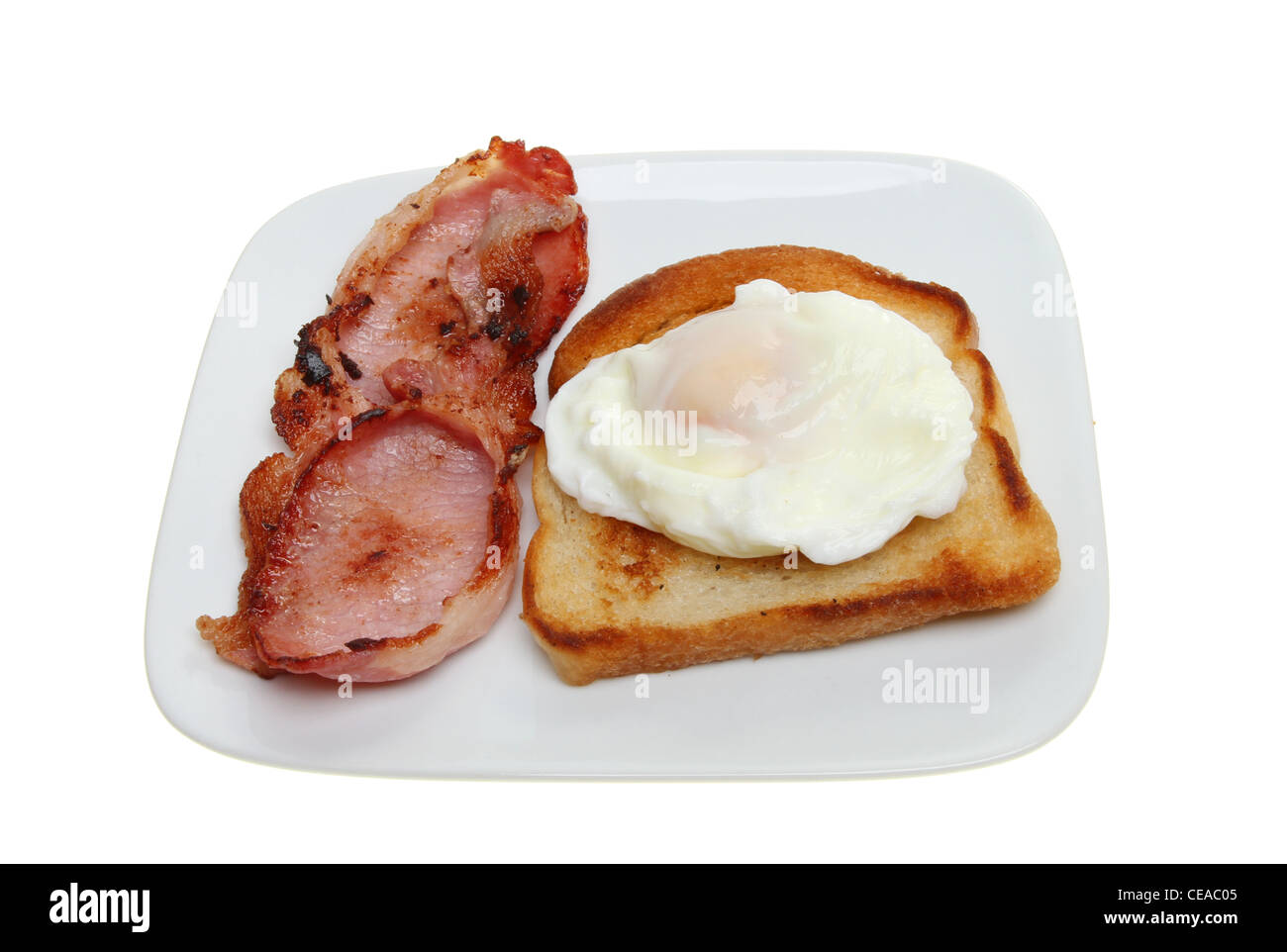 Oeuf poché, de bacon et de pain frit sur un plat blanc isolé contre Banque D'Images
