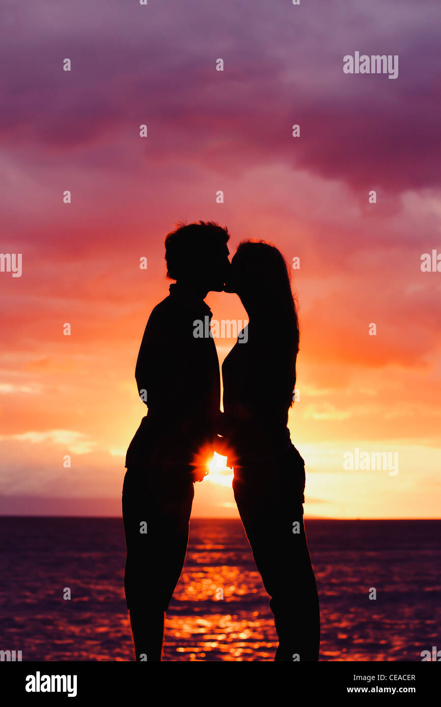 Silhouette de jeune couple romantique au coucher du soleil Banque D'Images