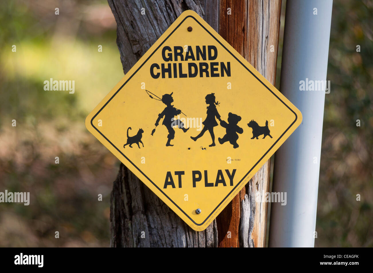 Petits-enfants jouer au panneau d'avertissement jaune dans la communauté de la retraite, Florida, United States, USA, Amérique du Nord Banque D'Images