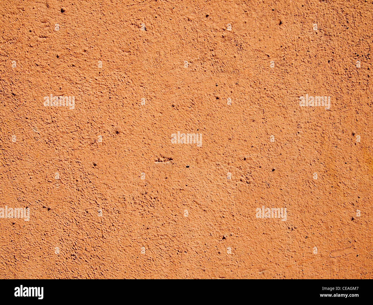 Orange en terre cuite ou en stuc de ciment Mur en plein soleil. Banque D'Images