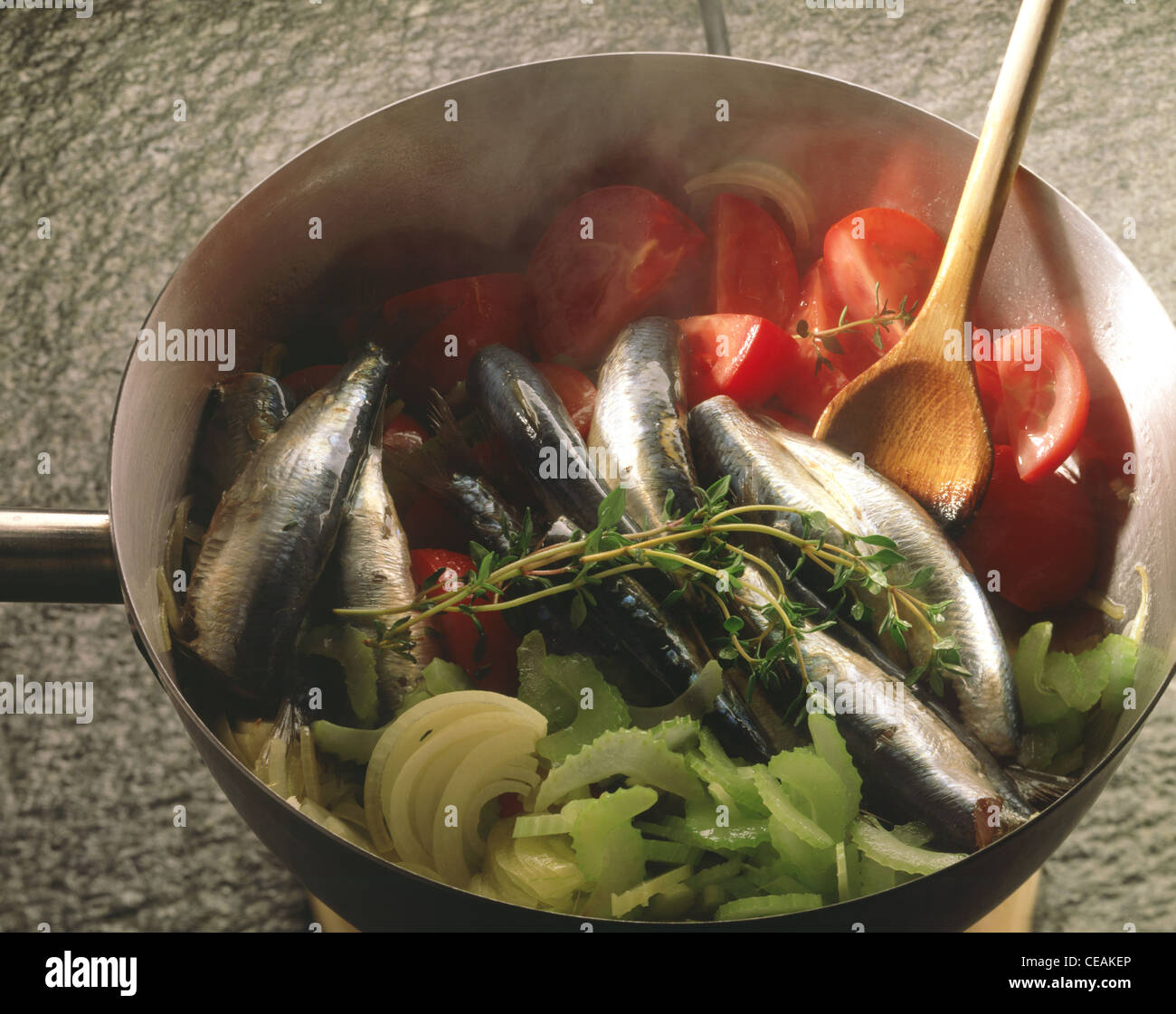 La cuisson des sardines avec des légumes Banque D'Images