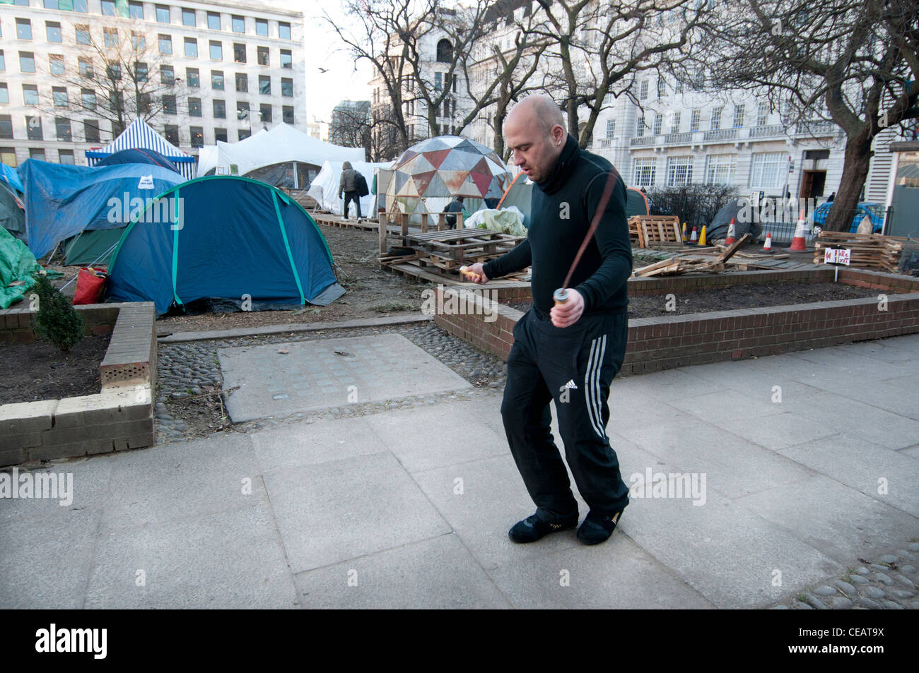 L'homme en sautant pour garder au chaud à Occupy London dans Finsbury Square Banque D'Images