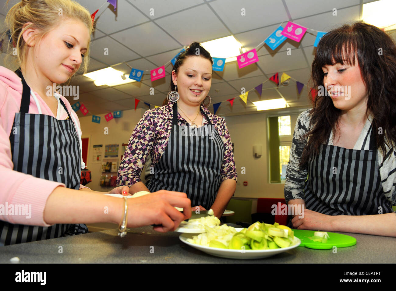 Les adolescents cook et en apprendre davantage sur la saine alimentation à un club de jeunes, West Yorkshire Banque D'Images